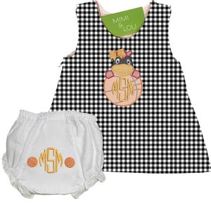 Può includere: Un set di vestito e mutandine per neonati a quadretti bianchi e neri. Il vestito presenta un design di ippopotamo ricamato con le iniziali "MSM" su un pallone da basket. Le mutandine sono bianche con finiture in pizzo e iniziali abbinate.