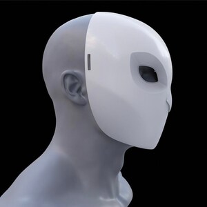 May include: A white mask with a sleek, modern design. The mask covers the face, featuring an eye opening and a small slit near the ear. The mask is displayed on a grey mannequin head against a black backdrop.