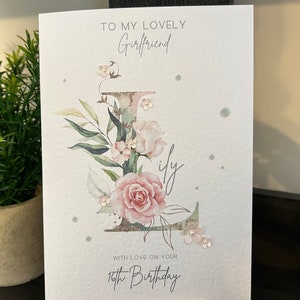 May include: A white card with a floral design and the text "To my lovely Girlfriend with love on your 16th Birthday".