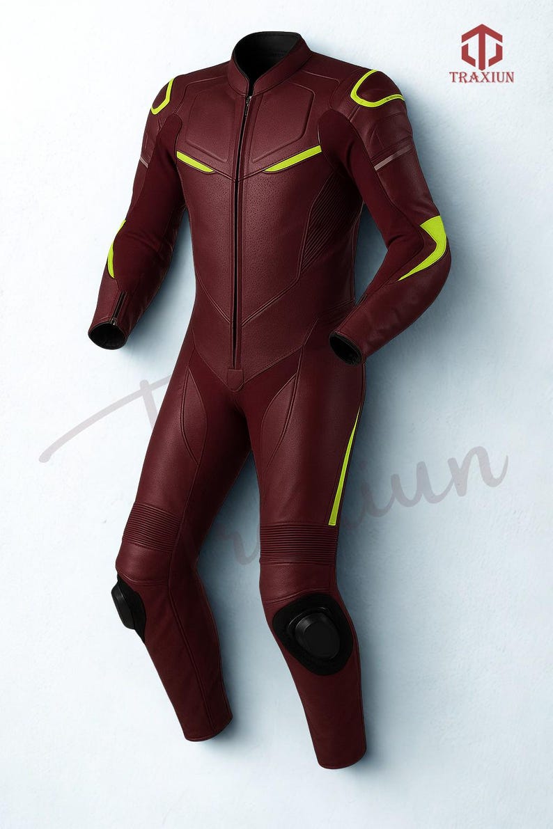 May include: A burgundy leather racing suit with neon yellow accents. The one-piece suit features a front zipper, padded knees, and black protective elements. The Traxiun logo is visible in the upper right corner.