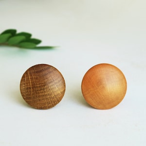 Peut inclure: Deux boutons en bois, l'un est de couleur brun foncé et l'autre est de couleur brun clair. Les deux boutons sont ronds et ont une surface lisse.