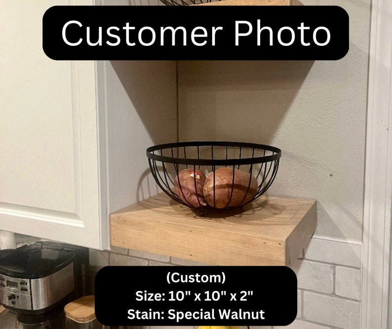 May include: A custom-made wooden shelf, stained in Special Walnut, is mounted on a wall. A black wire basket holds several brown vegetables. The shelf measures 25.4 cm by 25.4 cm and is 5.08 cm thick. The text "Customer Photo" is displayed.