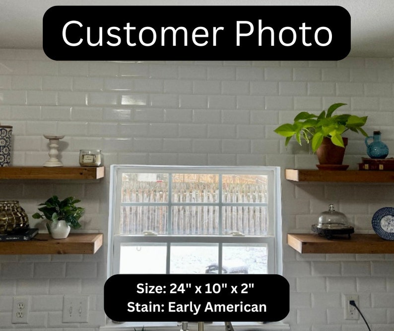 May include: A customer photo displays two wooden shelves, each measuring 61cm x 25cm x 5cm, stained in Early American. The shelves are mounted on a white tiled wall, with various decorative items.