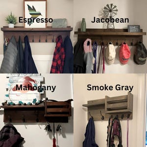 May include: Four wooden coat racks with shelves and hooks. The coat racks are shown in four different wood stains: Espresso, Jacobean, Mahogany, and Smoke Gray. Each rack has a shelf and five hooks. The Espresso rack has a picture of a bird on the shelf. The Jacobean rack has a small windmill on the shelf. The Mahogany rack has a snowman on the shelf. The Smoke Gray rack has a small mail slot on the shelf.