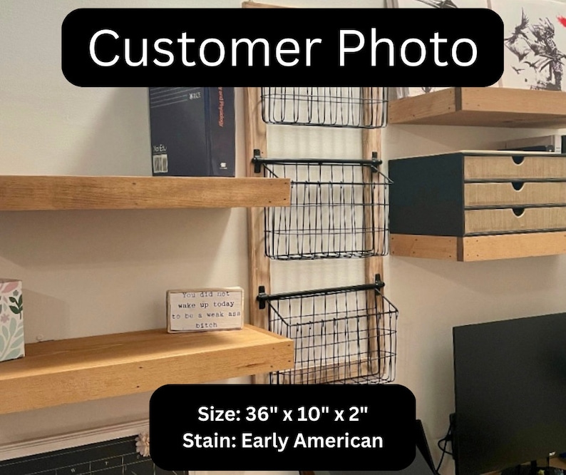 May include: A wall-mounted storage unit with three wire baskets and wooden shelves. The unit is 91 cm wide, 25 cm high, and 5 cm deep. The stain is Early American. The text "Customer Photo" is at the top.
