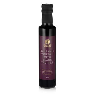 Op de afbeelding: Een donkere glazen fles balsamico-azijn met zwarte truffel. Het etiket is dieppaars met gouden tekst en een gouden embleem. De fles is 250 ml en heeft een zwarte dop.