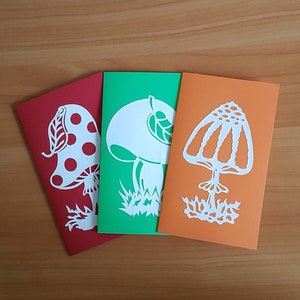 Jeu de cartes amusant. L'art des champignons. Art découpé en papier. Conception de champignons. Amanite mouche, champignon drôle, cèpes.