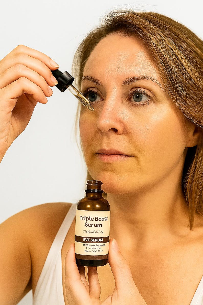 May include: A woman applying Triple Boost Eye Serum from a brown glass bottle with a dropper. The label reads "Triple Boost Serum" and "EVE SERUM". The serum is clear and the woman is wearing a white tank top.