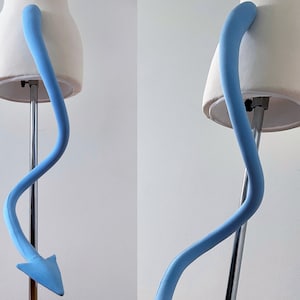 May include: A light blue, fabric-covered, tail prop with a pointed tip, attached to a white mannequin torso.