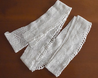 May include: White crocheted lace trim with a delicate pattern. The lace is folded in half and has a scalloped edge.