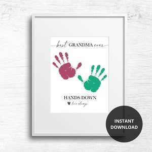 Op de afbeelding: Afdrukbare kunstprint met twee handafdrukken in roze en groen, met de tekst "best GRANDMA ever" en "HANDS DOWN love always".