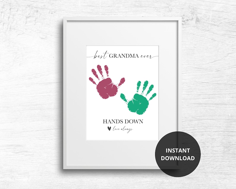 Op de afbeelding: Afdrukbare kunstprint met twee handafdrukken in roze en groen, met de tekst "best GRANDMA ever" en "HANDS DOWN love always".