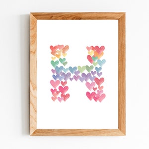 Puede incluir: Una impresión enmarcada de la letra H hecha de corazones de acuarela en colores arcoíris.