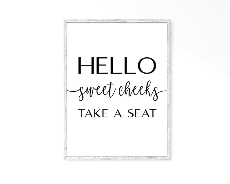 May include: A white framed print with black text that reads "HELLO sweet cheeks TAKE A SEAT".