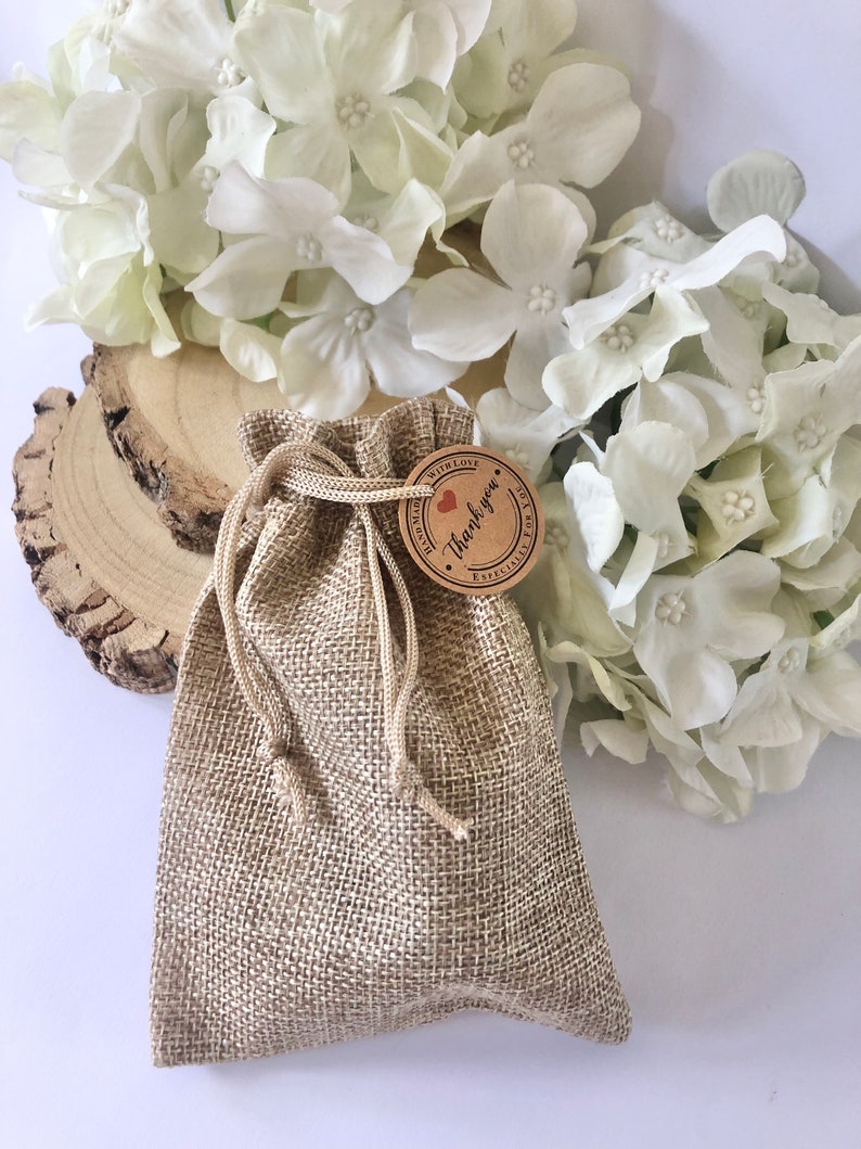 May include: A small hessian bag with a drawstring closure. The bag has a brown paper tag attached to it with the text "With Love, Thank you" and a small red heart.