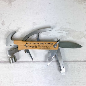 May include: A multi-tool with a hammer, pliers, and a knife. The handle is made of wood and has the text "Any name and choice of words (Can be engraved on both sides)" engraved on it.