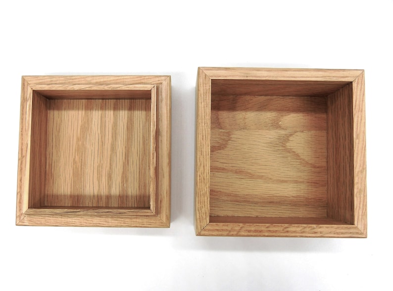 May include: Two wooden boxes with lids open, revealing the empty interior. The boxes are made of light brown wood with a natural grain pattern.