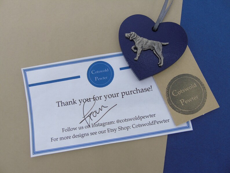 May include: A thank you card with a blue heart-shaped pewter charm featuring a silver dog. The card says "Thank you for your purchase!" and includes the text "Cotswold Pewter" and "Follow us on Instagram: @cotswoldpewter".