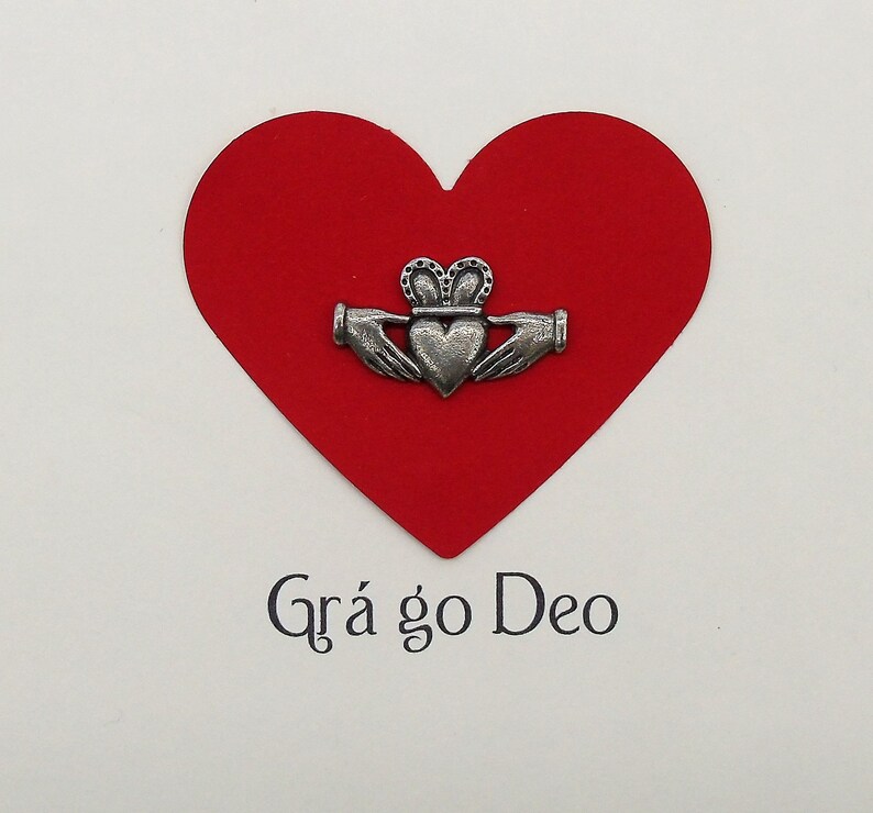 May include: A red heart with a silver Celtic knot design and the text "Gr&aacute; go Deo" on a white background.
