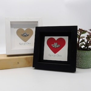 May include: Two framed pictures with a heart and a Claddagh ring. The heart is brown in one frame and red in the other. Both frames have the text "Gr&aacute; go Deo" which is Irish for "Love forever".