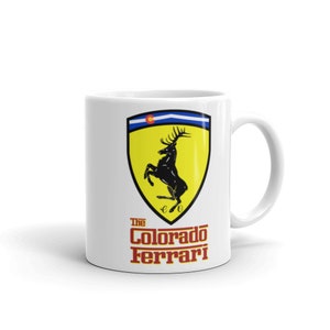 May include: White ceramic mug with a black and yellow logo featuring a rearing elk with antlers. The logo is surrounded by a red border and the text "The Colorado Ferrari" is printed below.