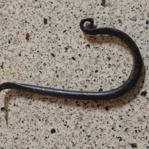 Może przedstawiać: Czarny metalowy hak o zakrzywionym kształcie z małą pętlą na górze.