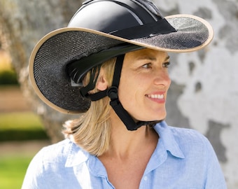 Pode incluir: Um capacete de equitação preto com uma aba de sol larga e removível, apresentando uma superfície de malha preta texturizada e uma borda bege. O capacete inclui uma tira de queixo preta ajustável com uma fivela acolchoada para ajuste seguro.