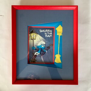 Cadre " smurfin in the rain "autour de l'illustration d'un schtroumpf