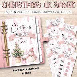 May include: A pink Christmas-themed savings planner with a binder, featuring a Christmas tree and snowman illustration. Includes savings challenges and sections labeled with amounts in Euros. The text reads "Christmas 1K Saver".