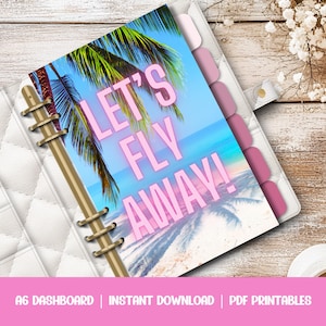 Op de afbeelding: Een witte A6-planner met een tropisch dashboard-inzetstuk. Het inzetstuk toont een strandscène met palmbomen en de tekst "LET'S FLY AWAY!" in roze. De planner is open en toont roze tabbladen.