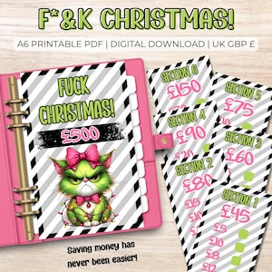 May include: A pink binder with a black and white striped design and the text "F*&K CHRISTMAS!" and "Saving money has never been easier!". The binder features a green cat with a pink bow and Christmas lights. Several cards with price sections are also visible.