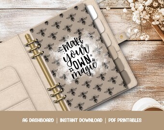 May include: A beige A6 planner with gold rings and a printable insert featuring a brown and white bee pattern and the text "Make your own magic".