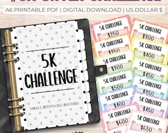 May include: A black binder with gold rings and a white page with the text "5K CHALLENGE". The image also includes colorful cards with amounts like $250, $300, and $400, promoting a savings challenge.