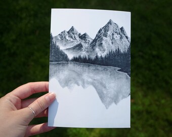 以下が含まれることがあります： 湖に映る山脈の白黒の絵。山は詳細に描かれており、反射は少しぼやけています。