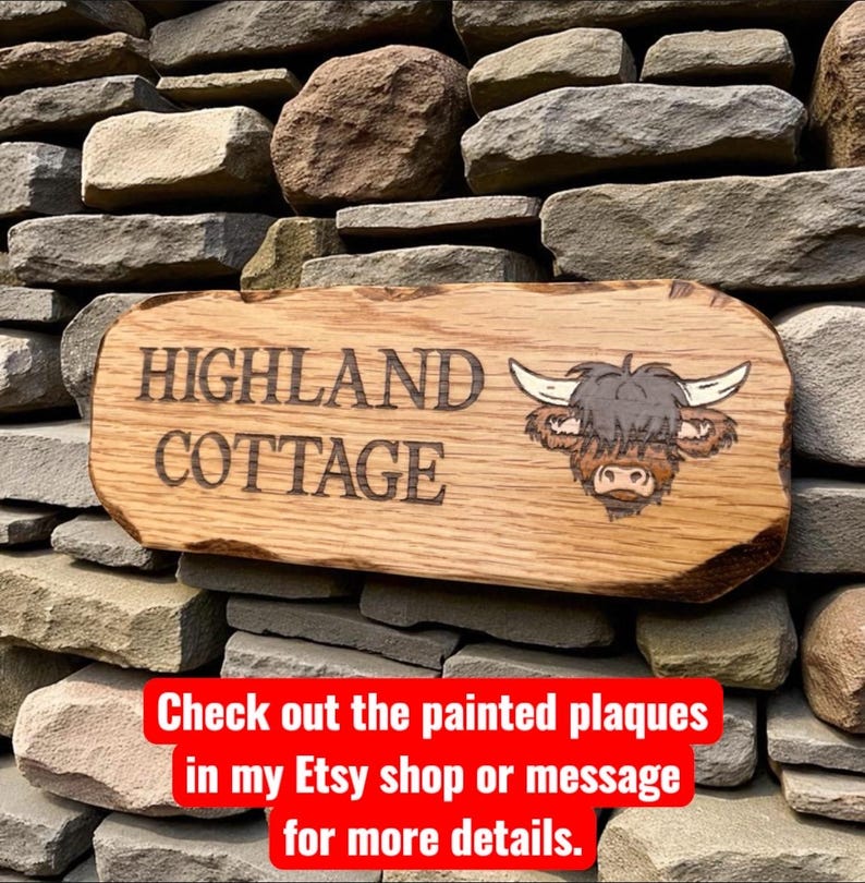 Pode incluir: Placa de madeira com a inscri&ccedil;&atilde;o "HIGHLAND COTTAGE" e uma ilustra&ccedil;&atilde;o de uma vaca Highland. A placa est&aacute; montada numa parede de pedra. A madeira tem um acabamento natural. O texto "Check out the painted plaques" tamb&eacute;m &eacute; vis&iacute;vel.
