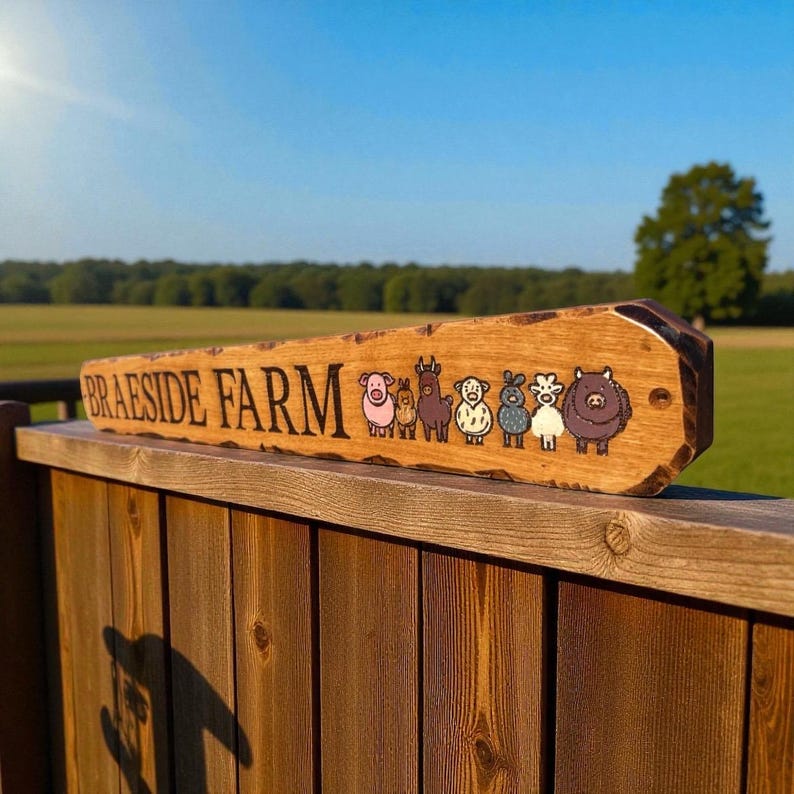 May include: A rectangular wooden sign with a natural live edge featuring the text BRAESIDE FARM in black lettering followed by a series of seven colorful cartoon animal illustrations including a pig, rabbit, llama, sheep, goat, and cow.