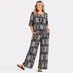May include: A two-piece set consisting of a short-sleeved top and wide-leg trousers, both featuring a black and white geometric diamond pattern. The trousers include a drawstring waistband and side pockets, paired with black thong sandals.