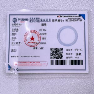 May include: A white rectangular identification certificate for a jade bangle with a total mass of 38.46g. The document features the certificate number HS2606087789, a circular graphic, a QR code, a barcode, and various Chinese text and official stamps.