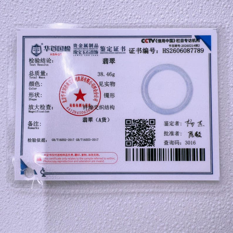 May include: A white rectangular identification certificate for a jade bangle with a total mass of 38.46g. The document features the certificate number HS2606087789, a circular graphic, a QR code, a barcode, and various Chinese text and official stamps.