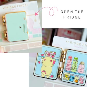 May include: A mint green enamel pin shaped like a refrigerator with gold hinges. The pin opens to reveal a yellow character inside with a bowl of strawberries and shelves stocked with colorful bottles, a carton, and three cans. Text reads FRIDGE FINDS.