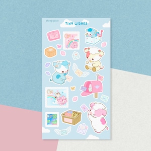 Peut inclure: Une planche d'autocollants intitulée TINY WISHES présentant diverses illustrations, notamment des vaches aux tons pastel, une boîte aux lettres rose, des enveloppes ailées, un panier de lettres, des arcs-en-ciel, des fleurs et des papillons.