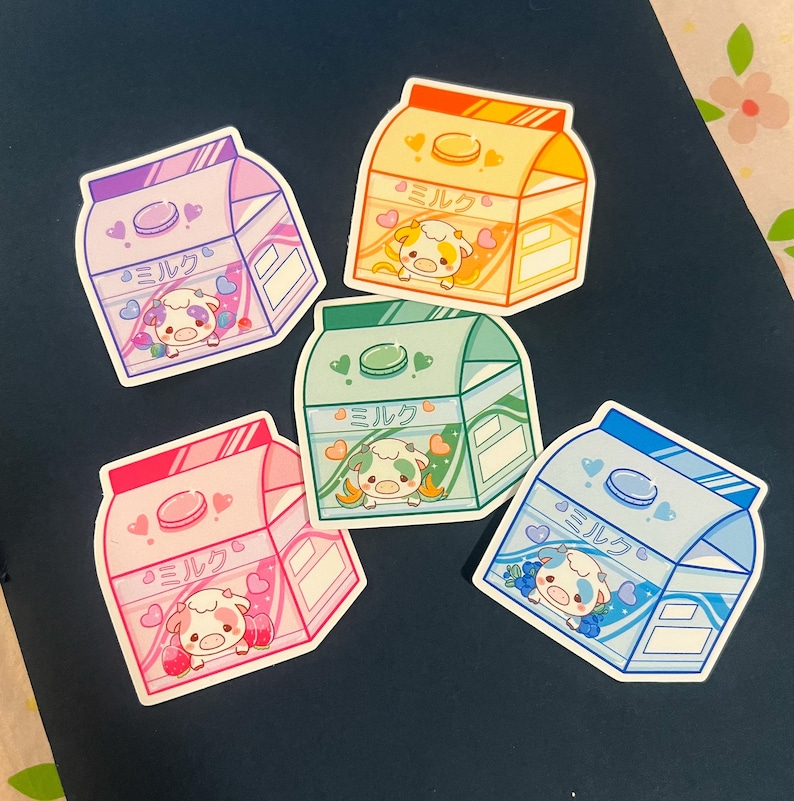 May include: Five colorful milk carton stickers with cartoon cows and the Japanese word "Milk" written on each. The stickers are on a dark gray background.