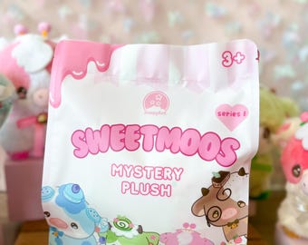 May include: A white and pink Sweetmoos Mystery Plush bag featuring cartoon cow illustrations. The bag has a pink drip design at the top and the text "Sweetmoos" and "Mystery Plush". The bag is marked "1 Piece" and "3+".