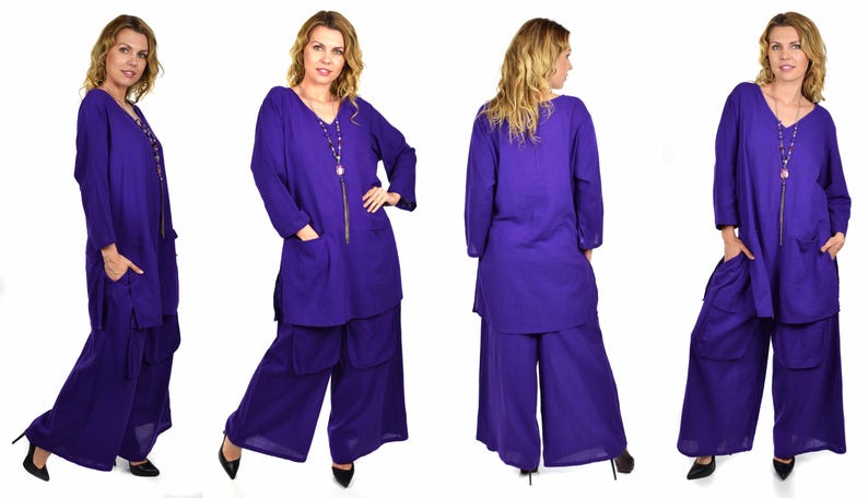 May include: A purple long-sleeved tunic top with a v-neck and two pockets, paired with matching wide-leg pants. The outfit is made of a soft, flowing fabric.