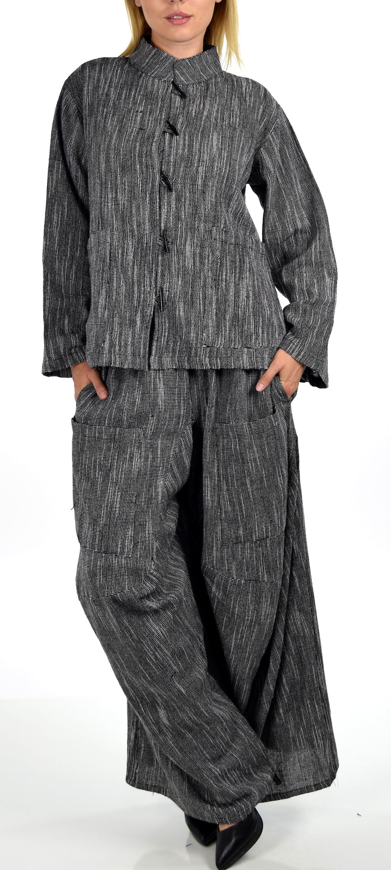 May include: A black and white striped linen jacket with a mandarin collar and a button closure. The jacket is paired with matching black and white striped linen pants.