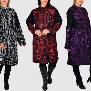 May include: Three long embroidered coats in black, red, and purple. The coats feature intricate floral and paisley patterns. Each coat has a mandarin collar and button closures. The models are wearing black leggings and boots.