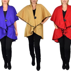 May include: Three women's fleece wraps in different colors: blue, tan, and red. Each wrap has a black trim and a single button closure.