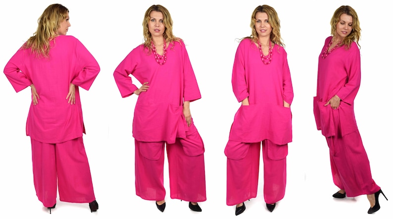 May include: A pink two-piece outfit with a long-sleeved top and wide-leg pants. The top has a V-neckline and pockets on the sides. The pants have pockets on the sides and are loose-fitting.