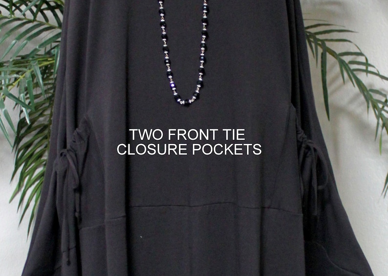 May include: Black long-sleeved tunic with two front tie closure pockets. The text "TWO FRONT TIE CLOSURE POCKETS" is printed on the front of the tunic.
