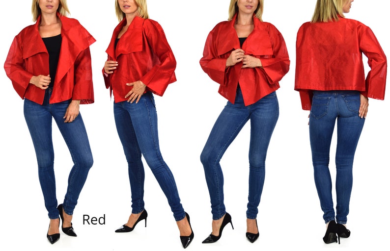 May include: A red cropped jacket with a draped collar and long sleeves. The jacket is worn by a model with blue jeans and black heels. The word "Red" is written in white text below the model.